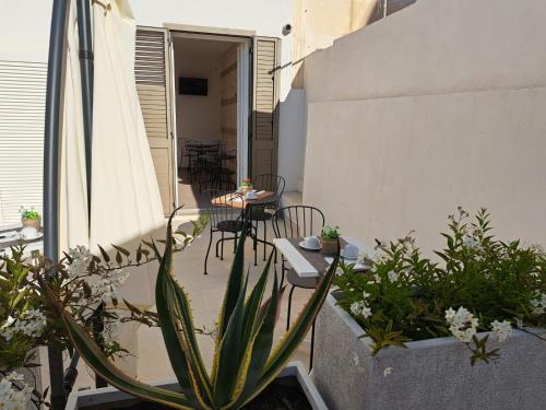 a patio with a table and chairs and plants at Le Dune Luxury Rooms in Vieste