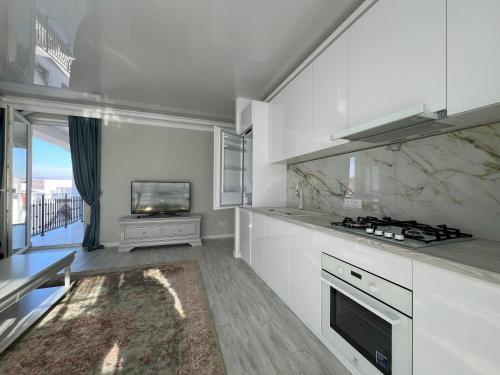 a kitchen with white cabinets and a stove top oven at COLLINE Rezidențial in Rediu