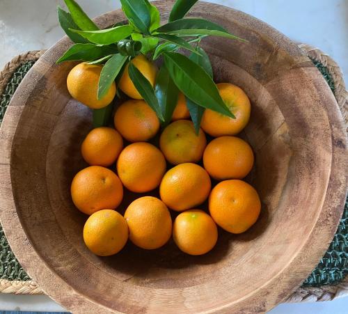 a bunch of oranges in a wooden bowl at Casa de Santiago in São Tiago de Besteiros