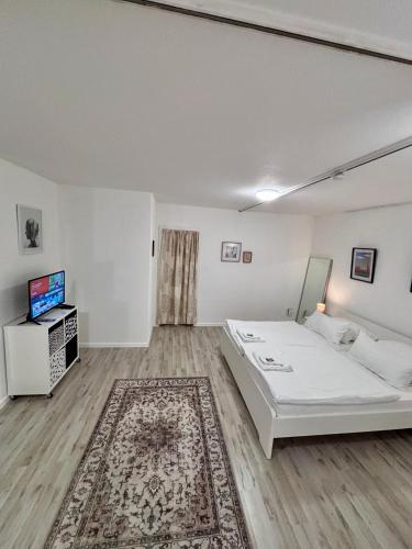 a white room with a bed and a television at Quartier Wenzelnberg in Langenfeld