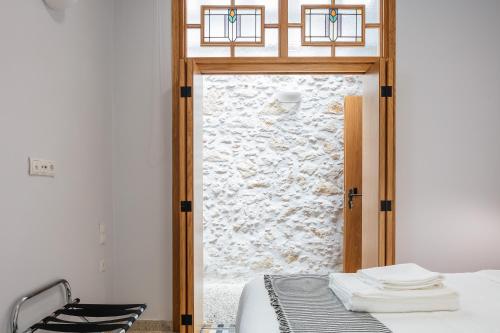 a bedroom with a bed and a glass door with a window at Chryssi 02, Comfort & Style, Centrally in Rethymno, close to the beach in Rethymno Town