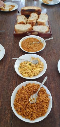 una mesa cubierta con platos de comida y pan en Olu Beach Villa, en Ambalangoda