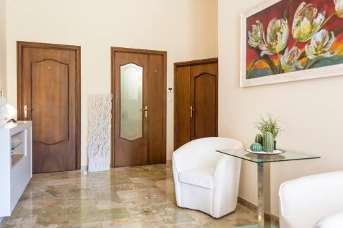 a living room with a white chair and a table at Villa Lazzari B&B Tra i due Mari in Maglie