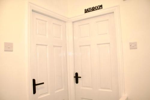 a white door with a sign on top of it at Cosy 2-Bed Home Near St Helens Centre - Free WiFi in Saint Helens