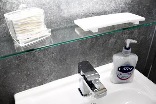 a bathroom sink with a bottle of soap on it at Cosy 2-Bed Home Near St Helens Centre - Free WiFi in Saint Helens