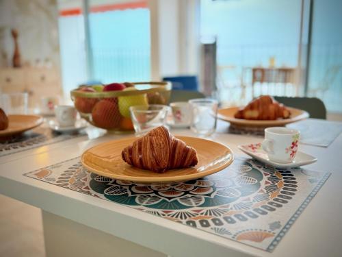 - une table avec des assiettes de pâtisseries et des tasses dans l'établissement Horizon bleu, à Les Sables-dʼOlonne