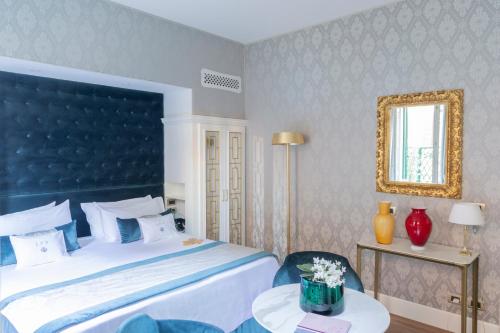 a bedroom with a large bed with a blue headboard at Londra Palace Venezia in Venice