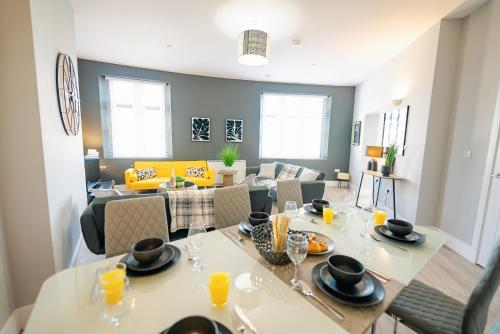a dining room and living room with a table and chairs at SPACIOUS & MODERN 3-BED & High Ceiling in Cardiff