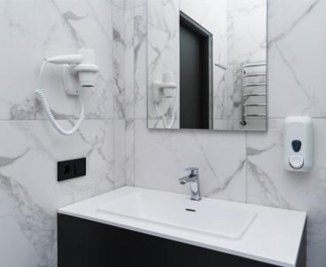 a bathroom with a white sink and a mirror at Sunrise Hotel in Kyiv