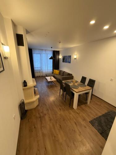 a living room with a table and chairs and a couch at From Sunrise to Sunset at Oak Residence Smolyan in Smolyan