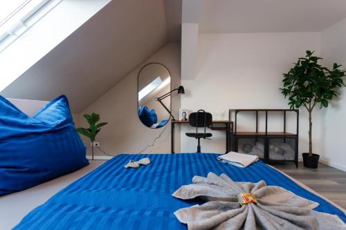 a bedroom with a blue bed with blue pillows at Macabu Apartment Linda in Chemnitz
