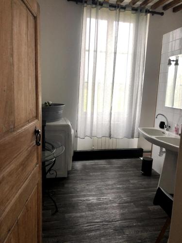 une salle de bain avec un lavabo et des toilettes et une fenêtre dans l'établissement L'hortensia, à Juaye-Mondaye