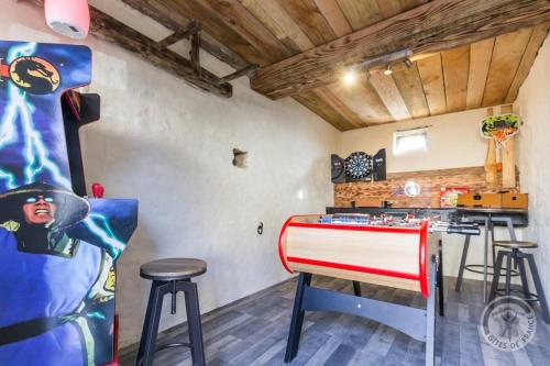 une cuisine avec un comptoir et des tabourets rouges et blancs dans l'établissement L'hortensia, à Juaye-Mondaye