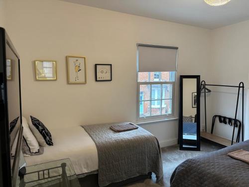 a bedroom with two beds and a mirror at Charming 2-Bedroom home in Leamington Spa in Leamington Spa