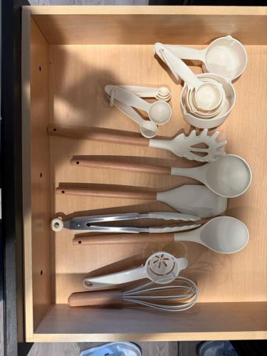 a wooden drawer filled with lots of utensils at Charming 1BR Getaway, Leander TX in Leander