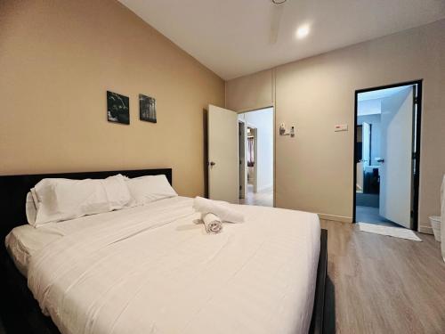 ein Schlafzimmer mit einem großen weißen Bett und einem Handtuch darauf in der Unterkunft New Island Luxe Retreat Vacation Home 14pax Nearby Gurney in Tanjung Bungah