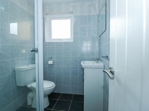 a bathroom with a toilet and a sink and a window at 59A South Snowdon Wharf in Porthmadog