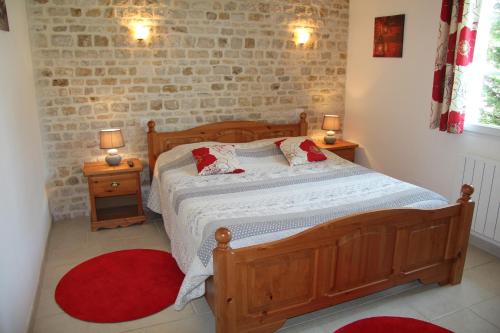 Un dormitorio con una cama de madera y dos mesitas de noche. en La Bergerie, en Romans