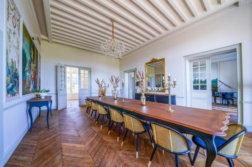 une grande salle à manger avec une longue table et des chaises dans l'établissement Magnifique château au cœur de la Touraine, à Esvres