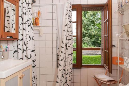 La salle de bains est pourvue d'une fenêtre et d'un rideau de douche. dans l'établissement Sweet country home in Normandy, à Verneuil-sur-Avre