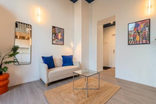 un salon avec un canapé et une table en verre dans l'établissement Grand studio pour deux personnes en mezzanine, à Villeneuve d'Ascq