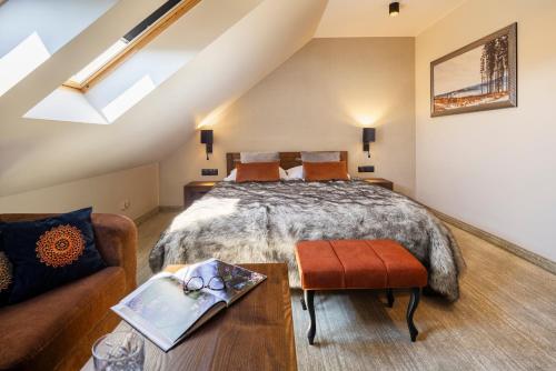 a attic bedroom with a bed and a couch at Złoty Groń Resort & Spa in Istebna