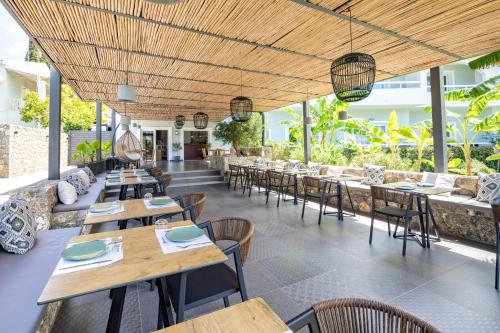 um restaurante vazio com mesas e cadeiras de madeira em La Maison Corfu - Adults Only em Ýpsos