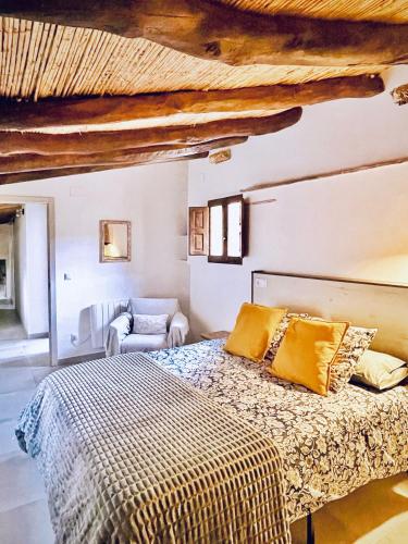 a bedroom with a bed and a chair at Ca Turón casa de pueblo in Planes
