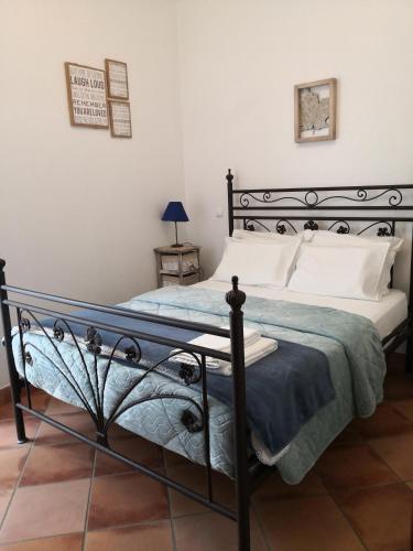 a bedroom with a black bed with white pillows at Casa do Suberco in Nazaré