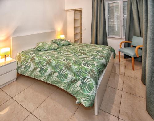 une chambre avec un grand lit et une chaise dans l'établissement Maison de charme à Monthenault avec terrasse et parking privé, à Monthenault