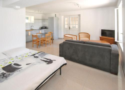 un salon avec un canapé et une cuisine dans l'établissement Maison de charme à Monthenault avec terrasse et parking privé, à Monthenault