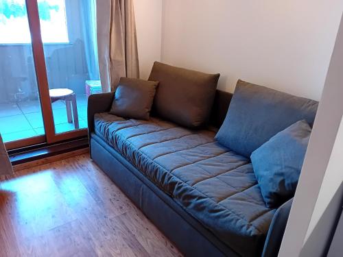 - un canapé avec deux oreillers dans le salon dans l'établissement Terrasses D 103 - PARC NAT VANOISE studio 2 pers, à Val Cenis