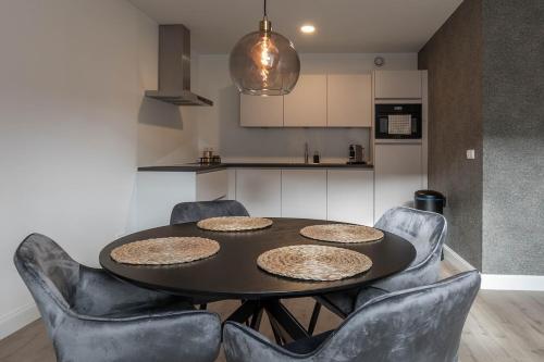 a dining room table with chairs and a kitchen at Luxe 3-kamer Penthouse met dakterras in het centrum van Hoorn in Hoorn