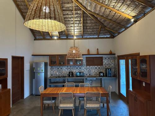 a kitchen with a wooden table and some chairs at Casa Tajo - Atins in Atins