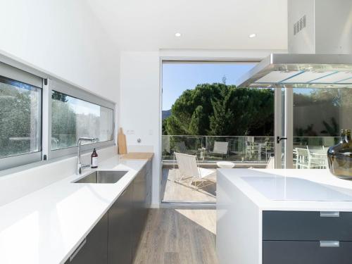 a kitchen with white counters and a large window at Akivillas Sintra Moon in Sintra