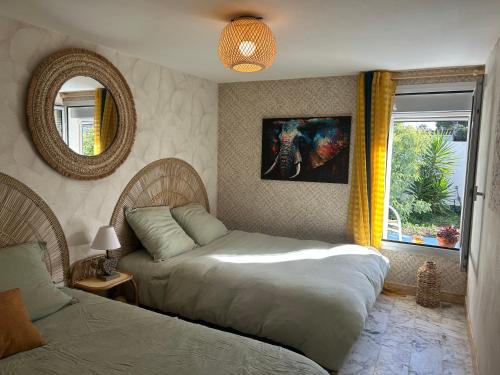 une chambre avec deux lits, un miroir et une fenêtre dans l'établissement La grangette, à Marseillan