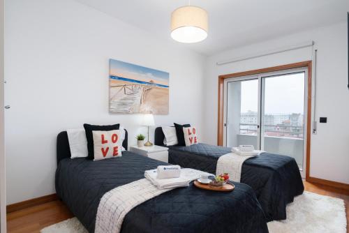 Un dormitorio con dos camas y una ventana. en Spacious Escape Near the Beach by Host Wise, en Matosinhos