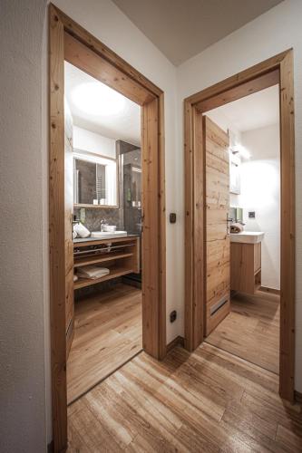 a bathroom with two wooden doors and a sink at Brunnenhof Oberstdorf - Ferienwohnungen mit Hotel Service in Oberstdorf