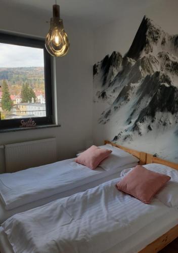two beds in a room with a mountain mural at Apartamenty Wakacyjne Historie in Międzylesie