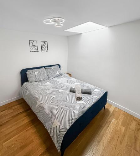 a bed in a room with a white wall at Havre de tranquillité à Maisons-Laffitte in Maisons-Laffitte