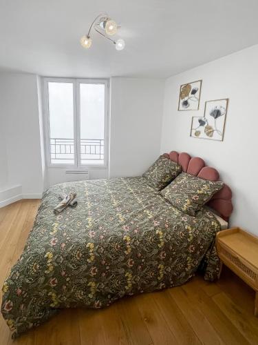 a bedroom with a bed with a comforter at Havre de tranquillité à Maisons-Laffitte in Maisons-Laffitte