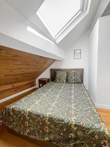 a bedroom with a bed with a green bedspread at Havre de tranquillité à Maisons-Laffitte in Maisons-Laffitte