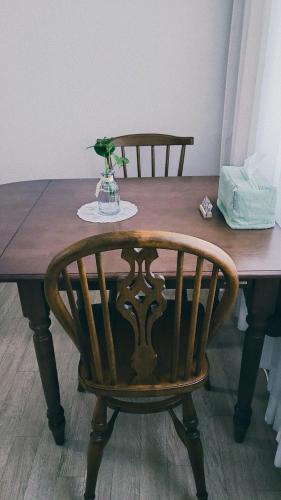 a wooden table with a wooden chair and a vase of flowers at Stay Foret in Seoul
