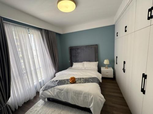 a bedroom with a bed with a teddy bear on it at Alba gardens in Nairobi