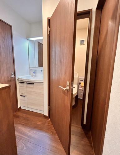 a bathroom with a wooden door and a sink at 京豊京都駅近辺 in Kyoto