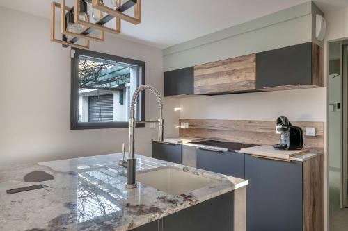 une cuisine avec un évier et un plan de travail dans l'établissement Maison moderne avec jardin pour 8 - La Baule, à La Baule