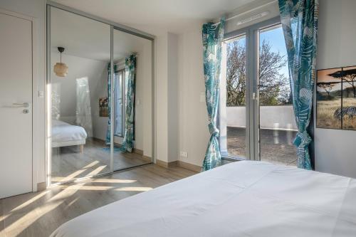 une chambre avec un lit et une grande fenêtre dans l'établissement Maison moderne avec jardin pour 8 - La Baule, à La Baule