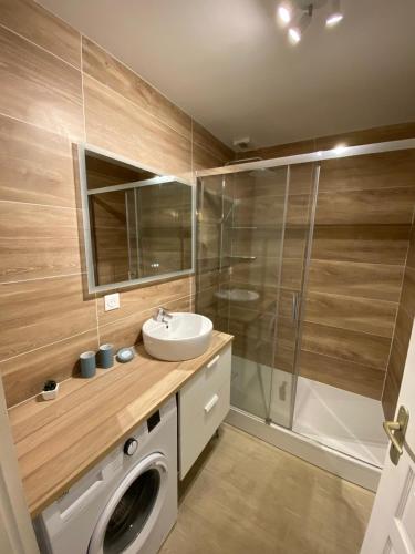 une salle de bain avec une machine à laver et un lavabo dans l'établissement Duplex moderne à 700m de la plage Parking & WiFi, à Fort-Mahon-Plage