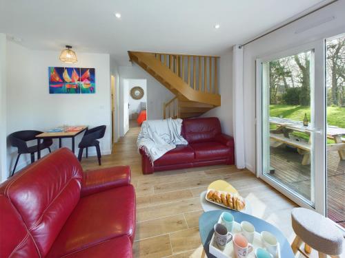 un salon avec un canapé rouge et une table dans l'établissement Maison pour 8 à Plomeur - Grand jardin, à Plomeur
