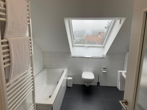 a bathroom with a tub and a toilet and a window at BestBoarding24 in Sulzbach am Main